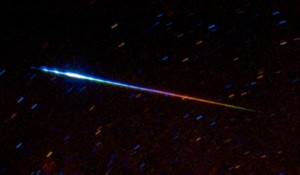 Earthgrazer: Above is a colorful example of a Perseid meteor (from the Perseid meteor shower of 1993). This type of meteor is known as an "Earthgrazer." Earthgrazers enter the sky from below the horizon, skim the atmosphere horizontally and leave a colorful and long trail. Earthgrazer meteors are seen in the early night, just after 9 p.m. Even though the colors in this image have been enhanced, they are representative of the colors seen when the meteor streaked across the sky. Image Credit and Copyright: S. Kohle & B. Koch (Astron. I., U. Bonn)